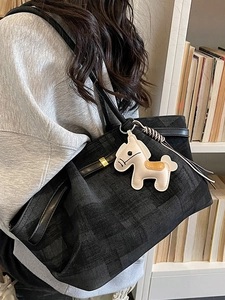 Large gray plaid tote bag with black leather straps and cream pony charm on shoulder