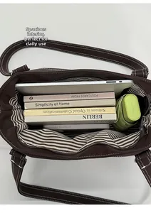Top view of large capacity tote bag interior with striped lining and daily essentials