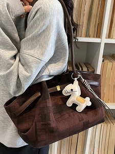 Large dark brown canvas tote bag with leather straps and white horse charm detail