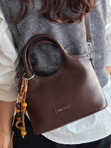 Minimalist dark brown bucket bag with a chic wood bead tassel and large capacity for women