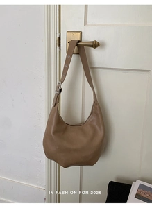 Detailed view of brown hobo bag showing soft leather texture and adjustable shoulder strap