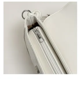 Détail du zip fluide argenté et de la tirette solide en métal sur le sac en cuir blanc
