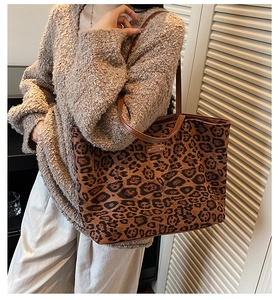 Détail du sac cabas en toile léopard vintage avec poignées en cuir et étiquette de marque