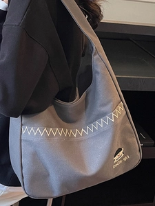 Grey canvas tote bag with girl print and embroidery shown on a model side view