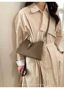 Close-up of khaki litchi grain leather bucket bag with elegant silver metallic buckle detail