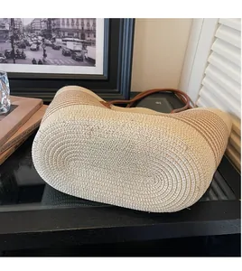 Detailed view of the woven spiral pattern and premium leather straps on this straw tote bag