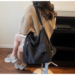 Detail view of the black large capacity nylon shoulder bag with functional pockets