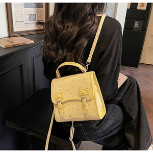 Detail of yellow bow-knot square bag with star pattern and PU leather texture