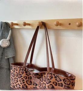 Détail du sac cabas à imprimé léopard suspendu à un crochet en bois, décor stylé