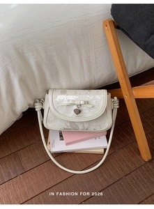 Détail du sac à bandoulière blanc à nœud avec breloque cœur et motif taches d'encre