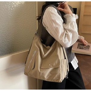 Detail view of khaki large capacity nylon tote bag with functional pockets and zippers
