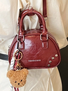 Sac à main chic bordeaux en cuir verni avec des détails rivetés et une écharpe décorative
