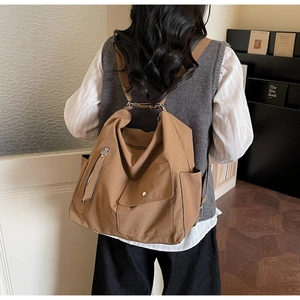 Detail shot of a camel large-capacity shoulder bag showing premium nylon texture and zippers