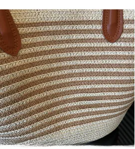 Close-up of horizontal stripe straw weaving texture and brown leather handle stitching
