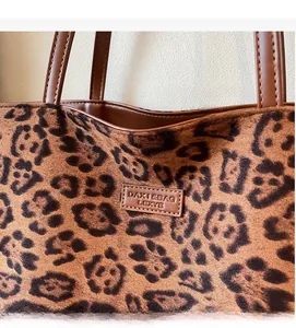 Gros plan sur la texture léopard du sac cabas avec bandoulière et détail du logo