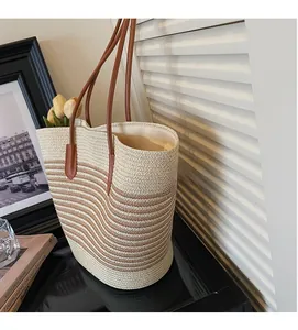 Close-up of handmade striped straw tote bag featuring detailed woven texture and leather straps