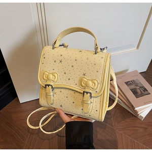 Detail of cream backpack with silver star print, 3D bows and metal buckle straps