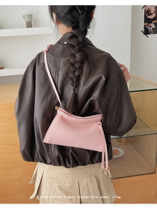 Pink minimalist faux leather crossbody bag worn by model showing size and soft texture