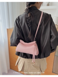 Pink crescent shoulder bag styled with black leather jacket for a vintage aesthetic