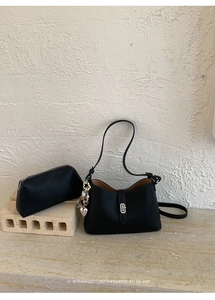 Minimalist black lychee leather shoulder bag with matching mini pouch and heart charm