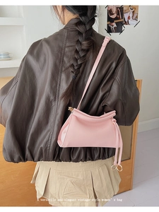 Detail of pink PU leather handbag featuring a stylish gold metal ring and long strap