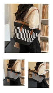 Detail of striped woven tote bag featuring brown leather handles and reinforced stitching