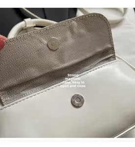 Detail of white leather pillow bag with strong magnetic clasp and herringbone lining