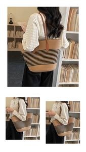 Detail of striped straw tote bag featuring brown slim handles and woven texture surface