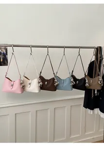 Detail of multi-color bucket handbags with metal twist locks and heart charms