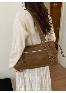 Detail of Muon Shark embossed texture on a brown textured leather shoulder tote bag