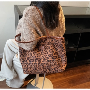 Sac fourre-tout à imprimé léopard stylisé avec un pull en tricot marron en intérieur