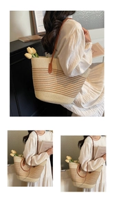 Close-up of woven straw tote bag with horizontal stripes and brown leather shoulder straps
