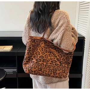 Détail du sac cabas léopard tendance avec anses brunes et étiquette de marque