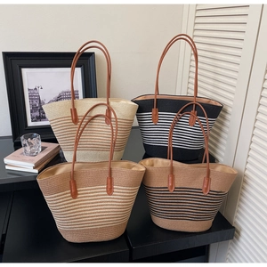 Detail of multi-colored striped woven straw tote bags with leather handles for beach vacation