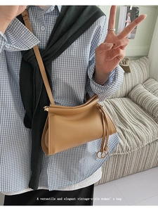 Détail du sac bandoulière vintage en cuir marron clair avec plis naturels et anneau en métal