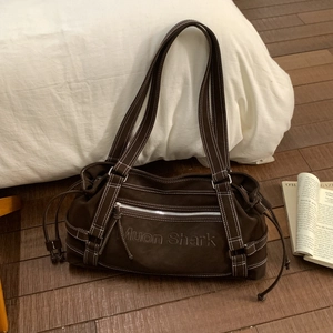 Close-up of coffee brown tote bag with white contrast stitching and Muon Shark embossing