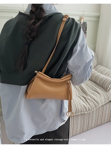 Detailed back view of a camel vintage crossbody bag with elegant top pleats and gold hardware