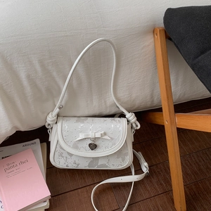 Détail d'un sac à bandoulière blanc en PU avec imprimé gris et pendentif cœur noeud
