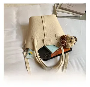 Top view of beige leather bucket bag interior showing phone and daily essentials