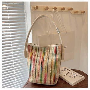 Detailed close-up of a colorful striped woven bucket bag with elegant metal buckle detail