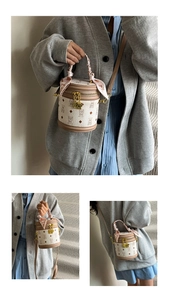Détail du sac seau cylindrique avec imprimé ours, poignée en soie et finitions dorées