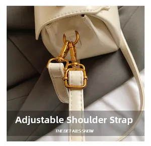 Détail de la bandoulière réglable en cuir blanc avec crochet doré pour sac à main