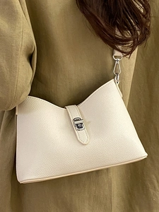 Elegant off-white lychee grain leather bucket bag styled with a green winter coat