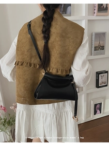 Detail view of the vintage black leather shoulder bag with metallic ring decoration