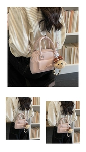 Close-up of pink casual crossbody bag with bow detail and cute teddy bear pendant