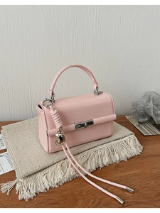 Details einer rosa PU-Lederhandtasche mit silbernem Drehverschluss und Herzanhänger