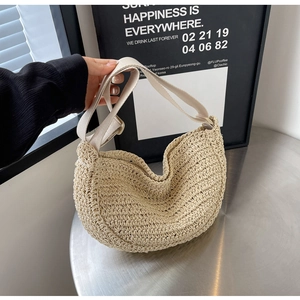 Dettaglio borsa a tracolla beige in paglia intrecciata con ampia tracolla regolabile in tessuto