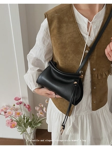 Détail d'un sac bandoulière vintage en cuir noir avec sangle fine et boucle en métal