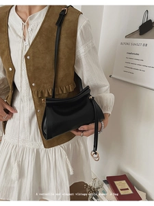 Détail du sac bandoulière vintage noir mat avec rabat plié et anneau métallique