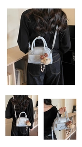 Detail of light blue bow bag with plush bear charm and textured synthetic leather